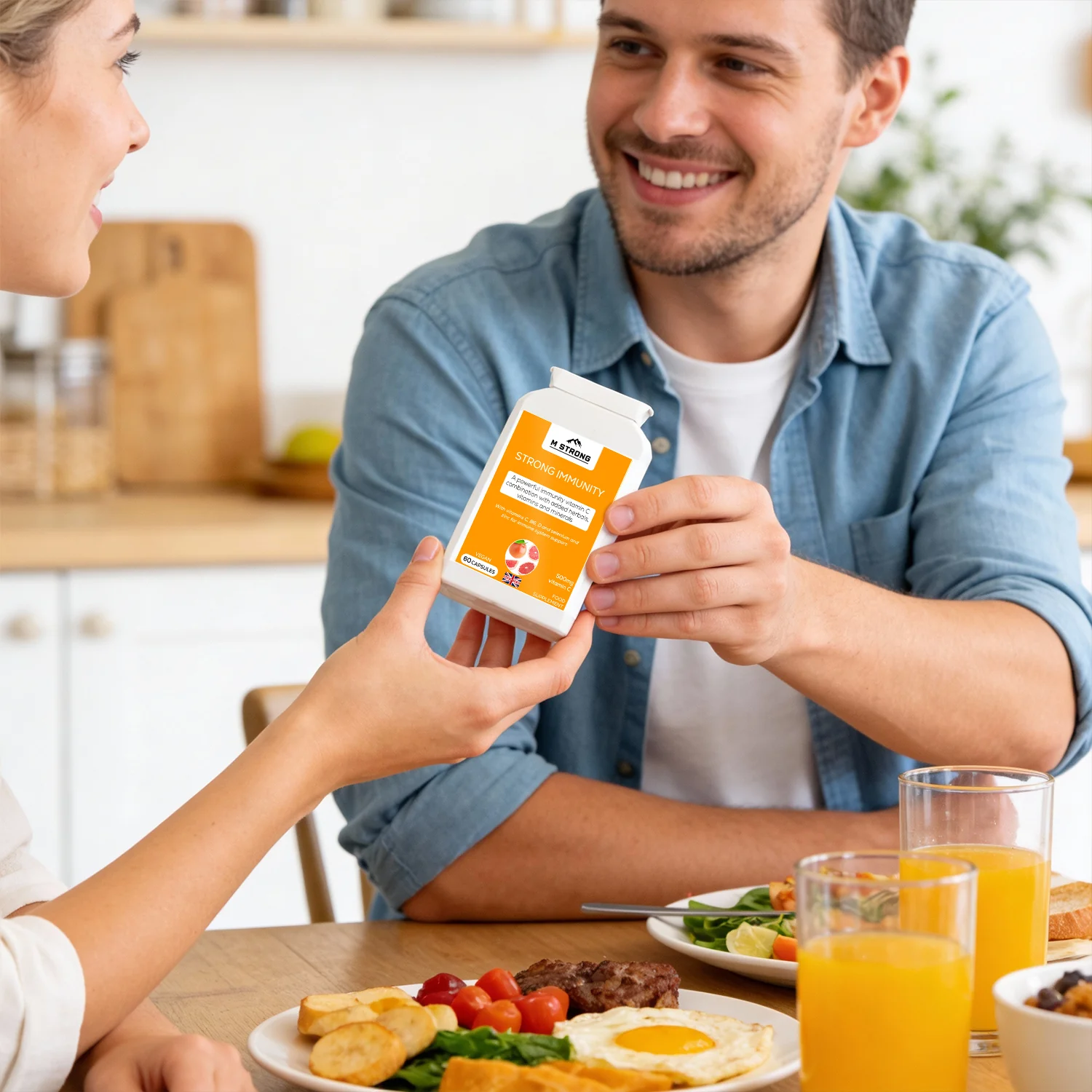 People holding M STRONG Strong Immunity vitamin C supplement during a meal as part of a daily routine